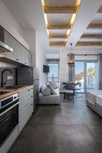 a kitchen and living room with a couch and a table at Vivere Luxury Suites in Pera Gyalos