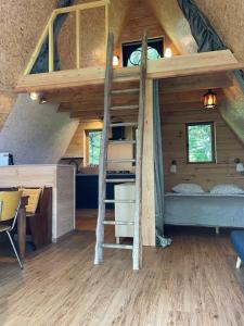 1 cama elevada en una casa pequeña en Domaine Le Rianon, en Malleret-Boussac