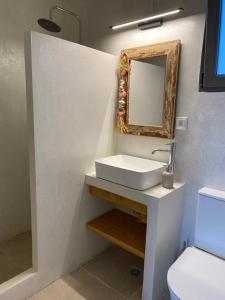 bagno con lavandino e specchio a parete di Deja blue villa 2 ad Agios Georgios