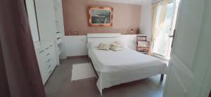 a white bedroom with a bed and a window at Perle in Nice
