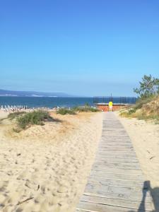 a boardwalk on a beach with the ocean in the background at Apartment Orhideya in Sunny Beach