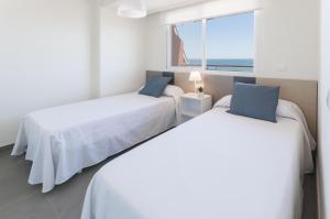 two beds in a room with a view of the ocean at AG Aquarium in Playa de Gandia +52 photos