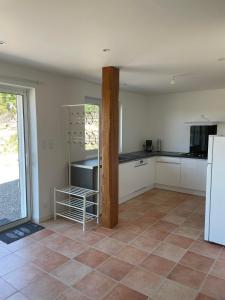 une cuisine avec des armoires blanches et un sol carrelé dans l'établissement Gîte Les Mimosas - 2 à 4 personnes - Vue imprenable, à Largentière