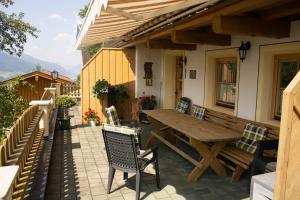 einen Holztisch und Stühle auf einer Terrasse in der Unterkunft Ferienwohnungen Zinzlerbauer in Uttendorf