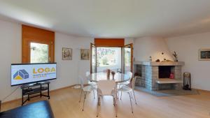 a living room with a table and a tv at Selvas in Sils Maria