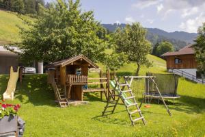 einen Spielplatz mit einem Spielset und einem Spielhaus in der Unterkunft Ferienwohnungen Zinzlerbauer in Uttendorf