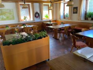 an empty restaurant with tables and chairs and windows at Gasthaus Sonne in Hohenstadt