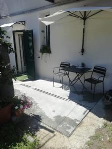 a patio with a table and chairs under an umbrella at La Cantinetta di Sve in Riccò del Golfo di Spezia