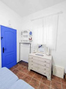 1 dormitorio con puerta azul y escritorio con ordenador. en “Flor de Sal” Charming Traditional Andalusian House, en Ayamonte