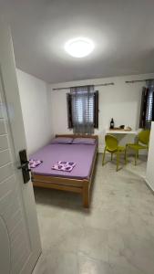 um quarto com uma cama roxa e algumas cadeiras em T&S ROOM em Budva