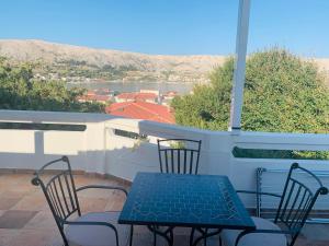 a table and chairs on a balcony with a view at Apartment Murvica in Pag