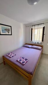 um quarto com uma cama grande e lençóis roxos em T&S ROOM em Budva