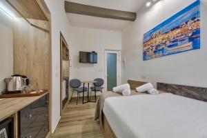 ein Hotelzimmer mit einem Bett und einem Tisch in der Unterkunft Tritoni Mini Studios - Valletta in Floriana