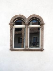 zwei Fenster an einer weißen Wand mit einem Tisch in der Unterkunft Marktplatz 10 in Kaltern