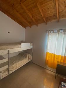 een slaapkamer met 2 stapelbedden en een raam bij Leams in Playa Unión
