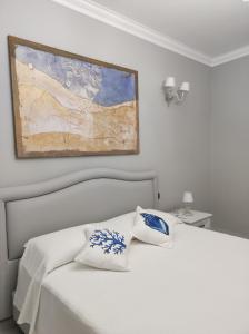 Un dormitorio con una cama blanca y una pintura en la pared en Lipari Suite B&B en Lipari
