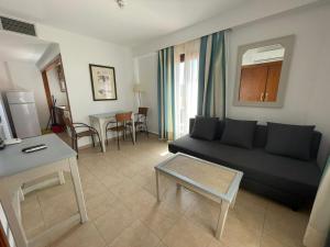 uma sala de estar com um sofá preto e uma mesa em APARTAMENTO PREMIUM UN DORMITORIO na Isla Canela