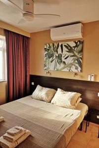 Schlafzimmer mit einem großen Bett und einem Ventilator in der Unterkunft Altea aan de jachthaven, vakantieappartementen met frontaal zeezicht in Altea