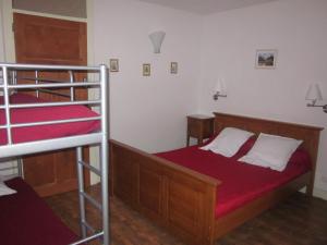 a bedroom with two bunk beds with red sheets at Gîte Les Mésanges in Thônes