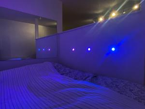 a bedroom with a bed with purple lights on it at Studio apt in quiet residential area 20min to city centre in Oslo