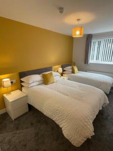 Duas camas num quarto com paredes amarelas em The seahorse em Blythe