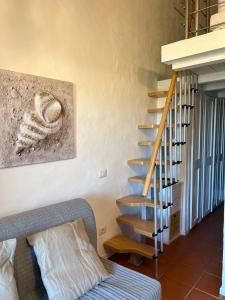 una scala a chiocciola in una camera con divano di Residence Ginepro, appartamento Baia Caddinas a Golfo Aranci