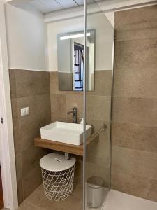 bagno con lavandino, servizi igienici e specchio di Residence Ginepro, appartamento Baia Caddinas a Golfo Aranci