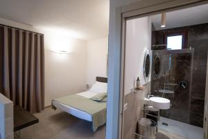małą sypialnię z łóżkiem i umywalką w obiekcie Setteminne Resort Design w mieście Favignana