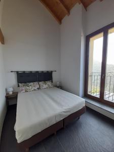 a bedroom with a large bed and a large window at Cascina Teresina in Veleso