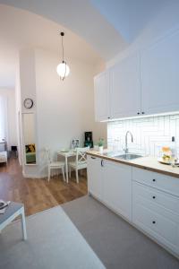 a white kitchen with a sink and a table at Friends Hostel & Apartments in Budapest
