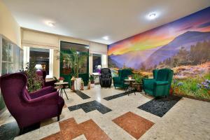 a lobby with chairs and a painting on the wall at Hotel Wiosna in Rabka-Zdrój