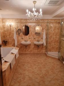 a bathroom with two sinks and a chandelier at VILLAS and SUITES LA CORAILLERE RESORT in Théoule-sur-Mer