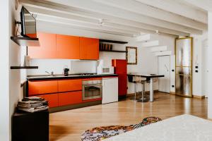 eine Küche mit orangefarbenen Schränken und einem Tisch darin in der Unterkunft La Piu' Bella Verona in Verona