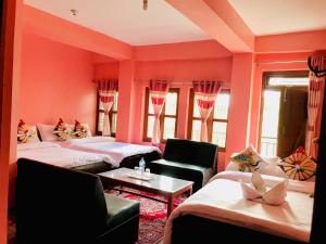 uma sala de estar com duas camas e um sofá em Shristi Hotel & Lodge em Bandipur