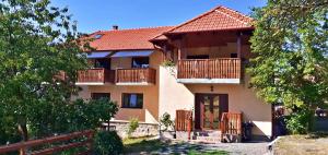 Cette grande maison dispose d'un balcon en bois et d'une clôture. dans l'établissement Pensiunea Agroturistica Ica, à Valea Drăganului