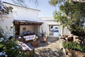 a patio with a couch and chairs in front of a house at Villa dei Tramonti in Porto Rotondo