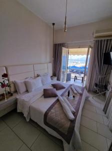 a bedroom with a large bed with a view of the ocean at marilena in Néa Epídhavros