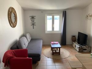 ein Wohnzimmer mit einem Sofa und einem Tisch in der Unterkunft Appartement moderne, vue imprenable in Bages