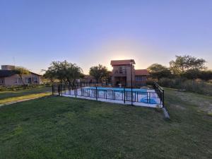 una piscina en un campo frente a un edificio en Cabañas San Pío en Merlo