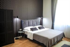 a bedroom with a large bed with two pillows at Hedone City Luxury Apartments with FREE PARKING in Pula