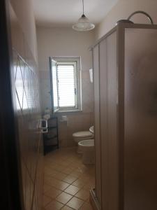 a bathroom with a toilet and a window at Casa Garri' Sciconi di Briatico in Briatico