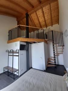 um quarto com um loft com uma escada em espiral em Cascina Teresina em Veleso