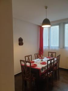 tavolo da pranzo con sedie e tenda rossa di Vintage Downtown Hostel a Braşov