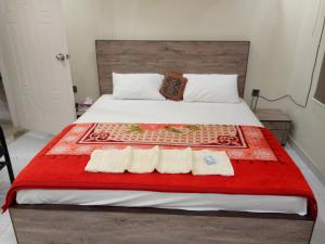 een slaapkamer met een bed met twee handdoeken erop bij Pearl Cottage Guest House in Karachi