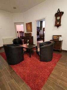 un soggiorno con 2 sedie e un tappeto rosso di Vintage Downtown Hostel a Braşov