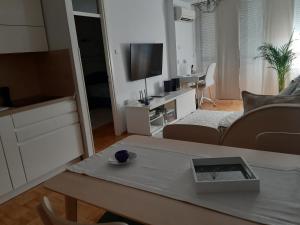 sala de estar con sofá y mesa con TV en Apartma EVA, en Koper