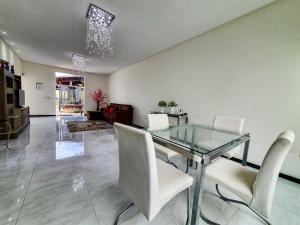 卡寧德聖弗朗西斯科的住宿－Caminho das Águas do Chico，一间设有玻璃桌和白色椅子的用餐室