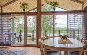a dining room with a table and a large window at Amazing Apartment In Frgelanda With Kitchen in Färgelanda
