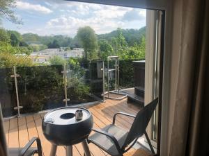 a balcony with a table and chairs and a large window at Honey lodge in Caeathro