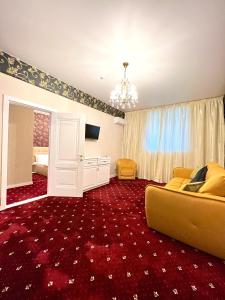 - un salon avec un canapé jaune et un tapis rouge dans l'établissement Sergeev Hotel, à Mykolaïv